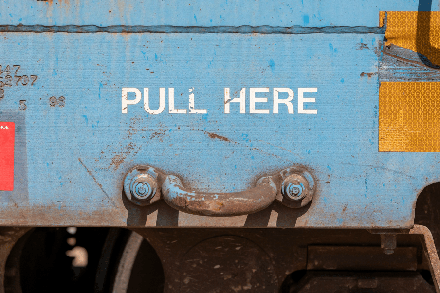 A blue metal trunk with the words 'pull here' stencilled in white paint on it.